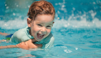 Dečkić u vodi uči plivati