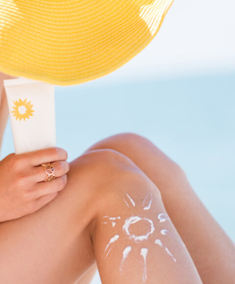 Žena na plaži sa kremom za sunčanje