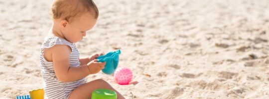 mala beba se igra na plaži s kanticama