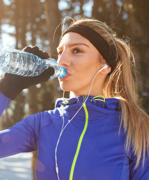 Žena pije vodu iz plastične boce